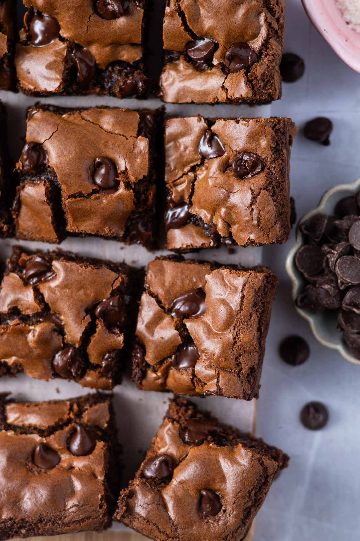 cookie bar squares with a bowl of chocolate chips and flaky sea salt