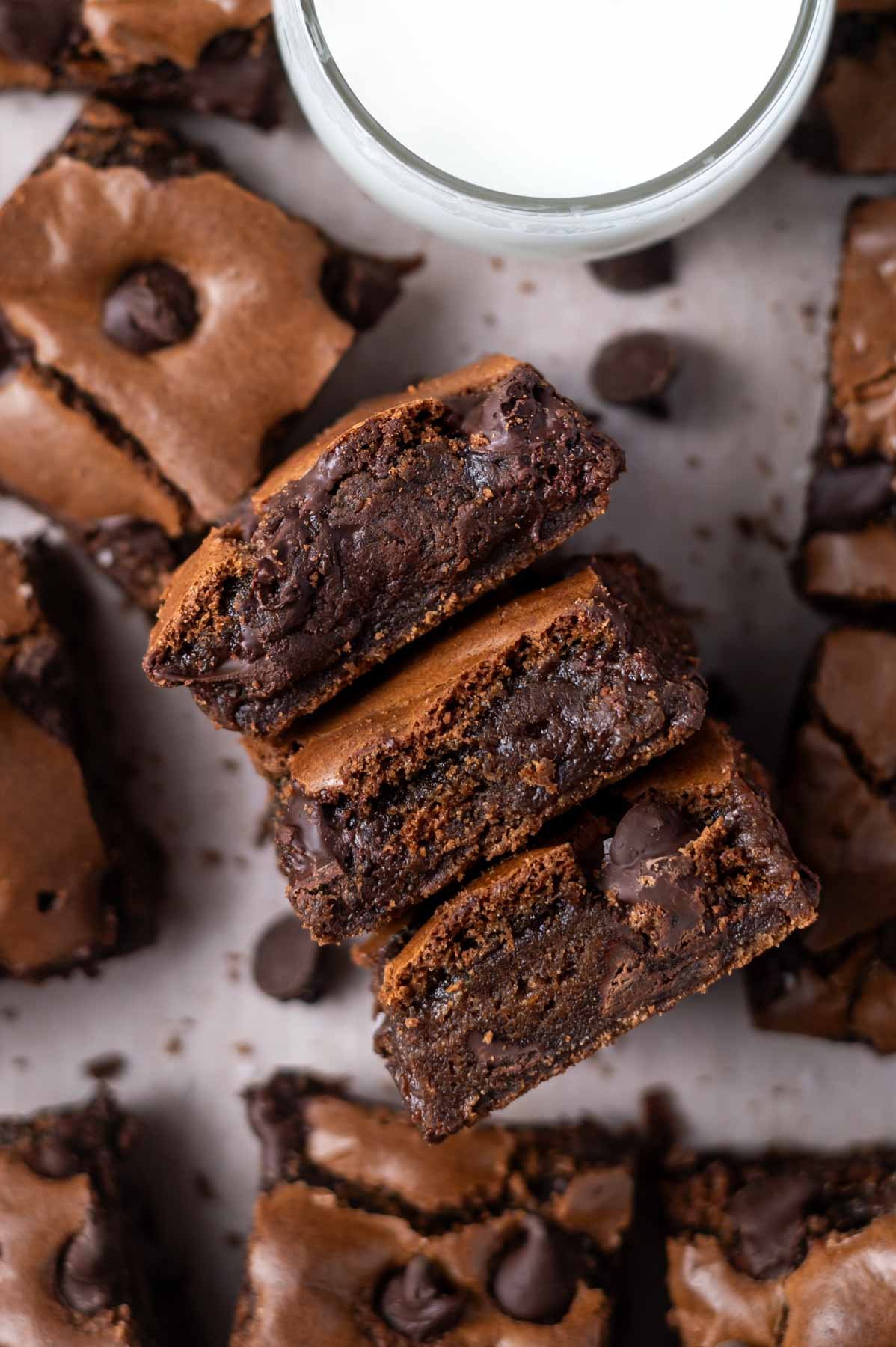 glass of milk with double chocolate cookie bars showing fudgy and soft centers