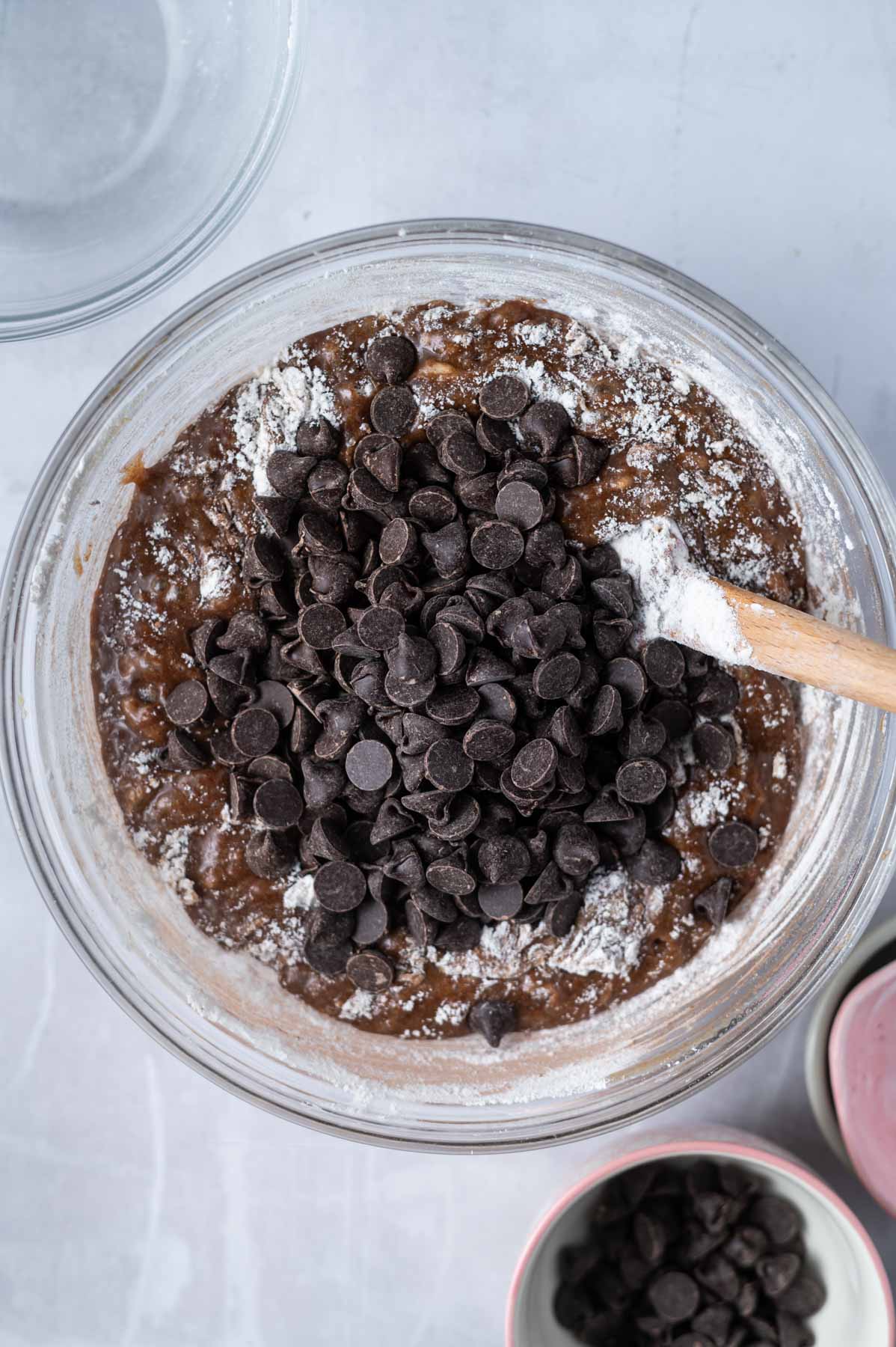 flour, cocoa powder and chocolate chips added to glass mixing bowl