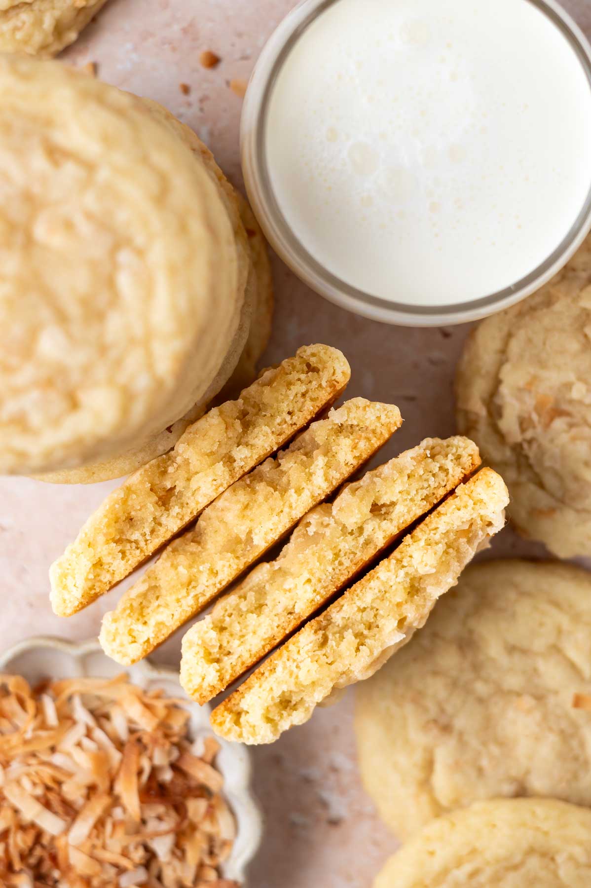 cookies broken in half with a glass of milk
