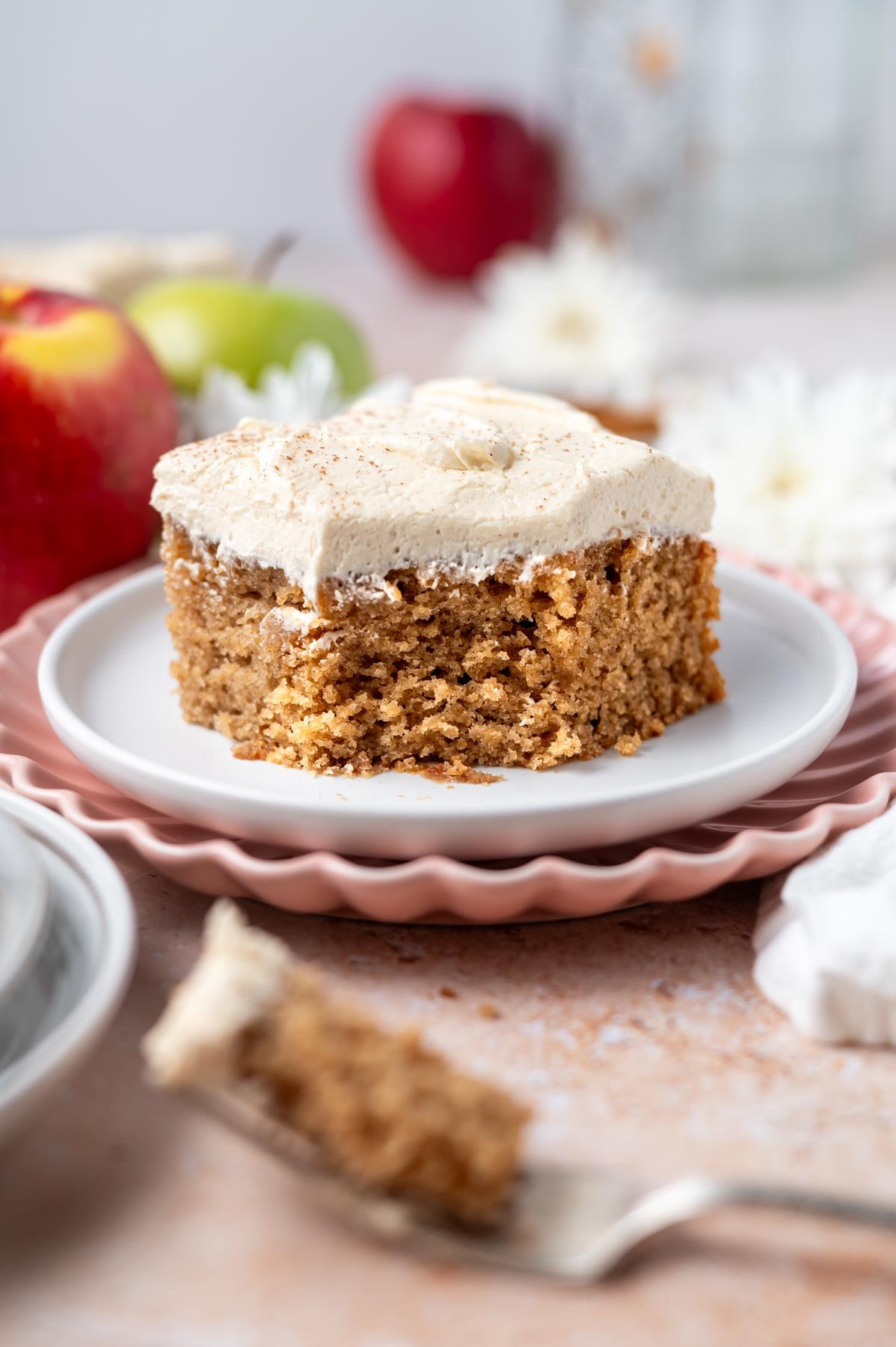 slice of apple snack cake with brown sugar frosting on a plate