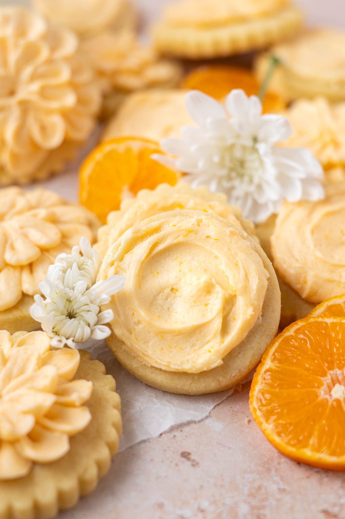 orange sugar cookies with orange slices and flowers on parchment paper
