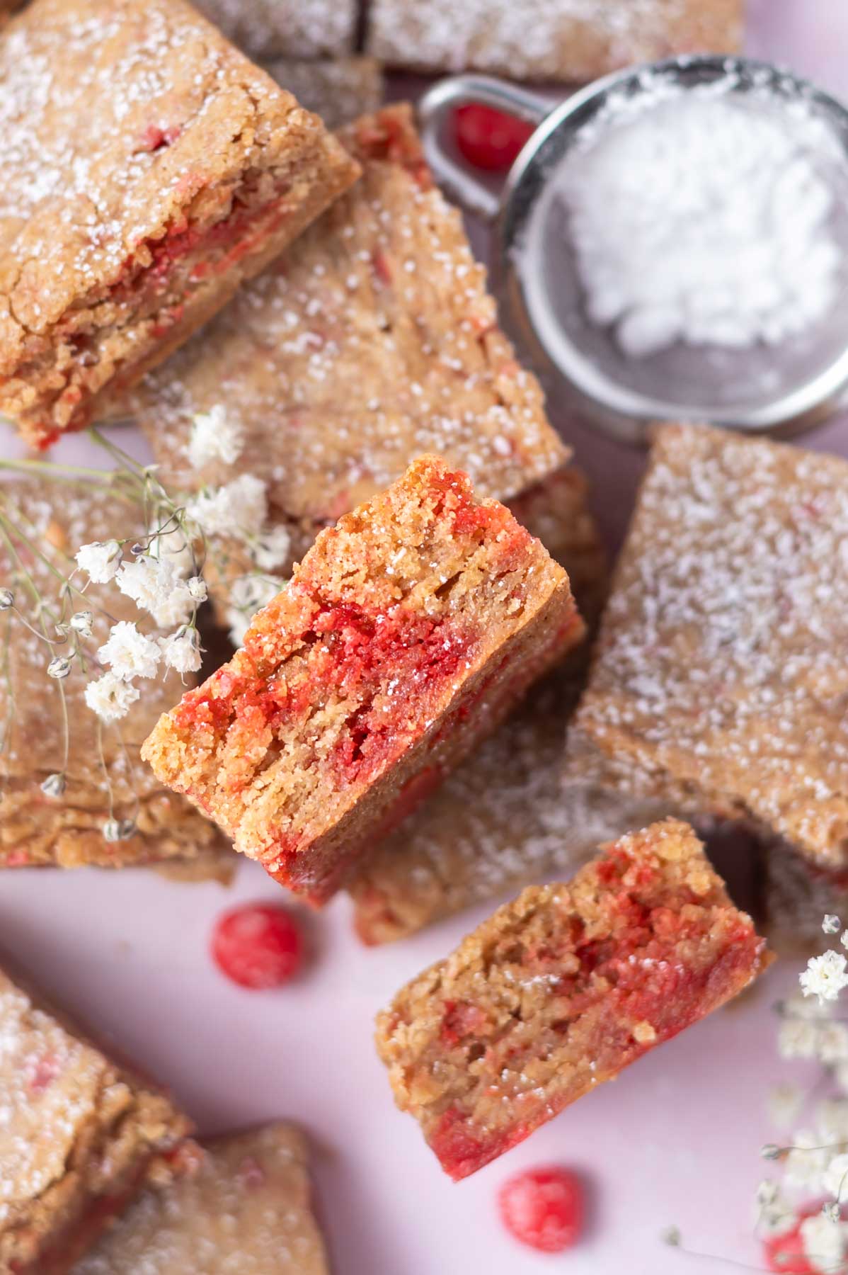 pile of blondies with some on their sides showing soft, cinnamon candy filled centers