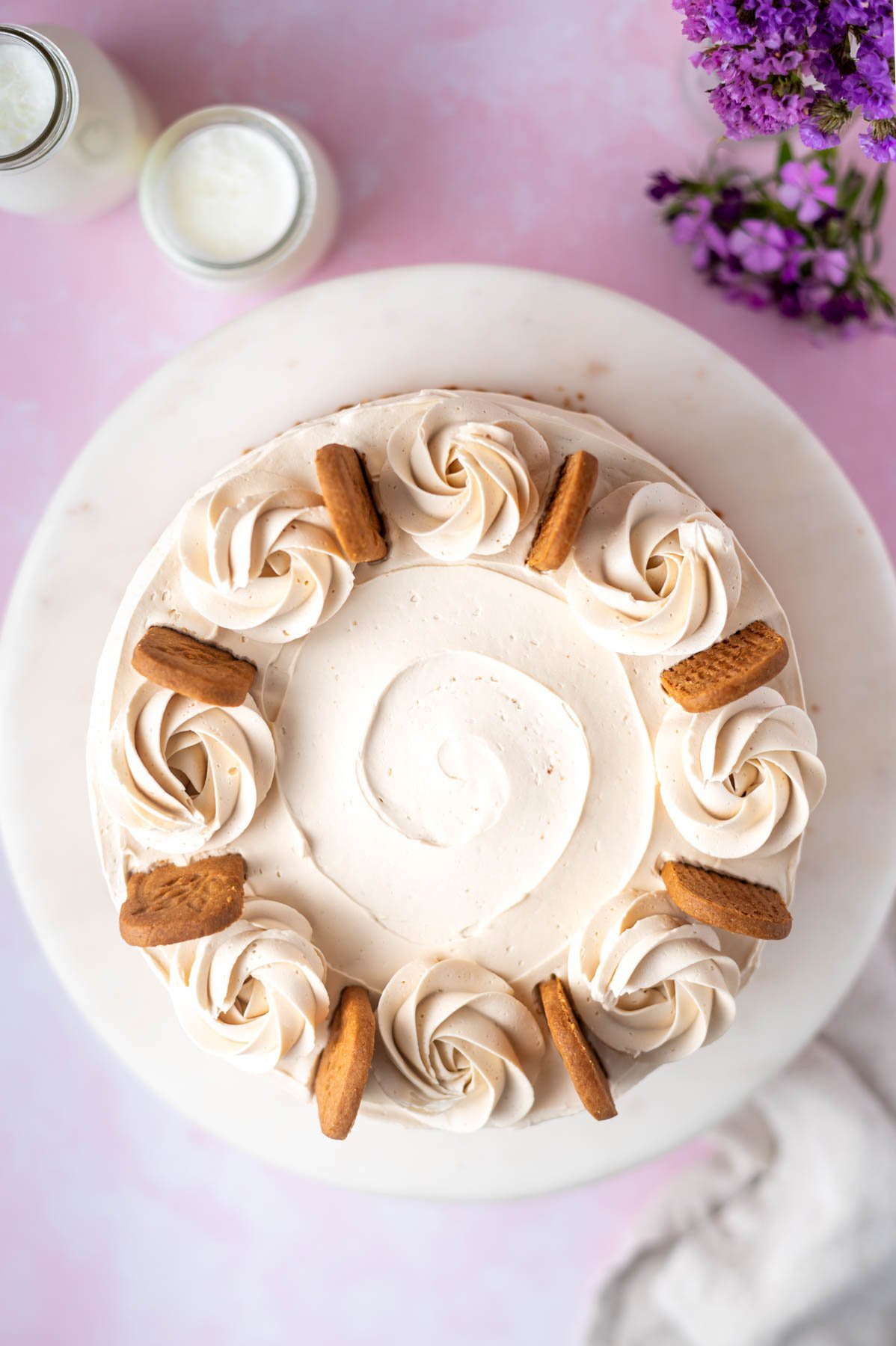overhead look at a decorated cookie butter cake with frosting swirls and cookie pieces
