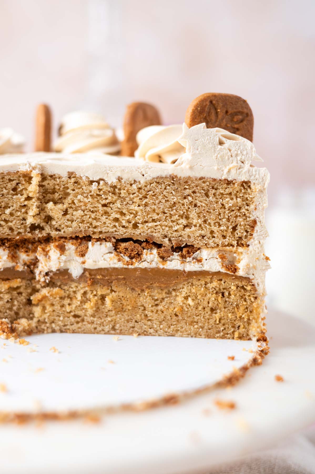 cookie butter cake slice showing the layers and filling on a cake stand