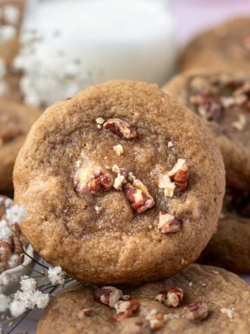 maple pecan cookie with a glass of milk in the background