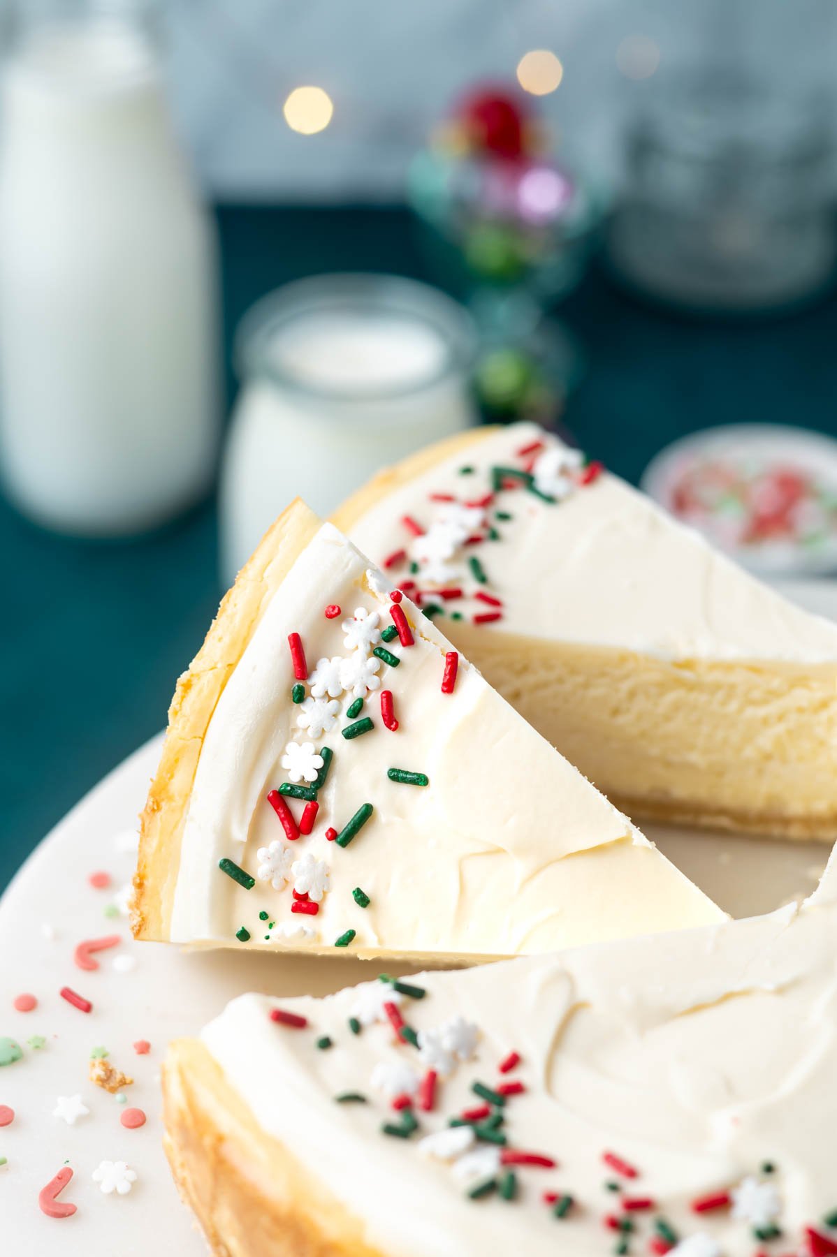 slices of sugar cookie cheesecake on a cake stand