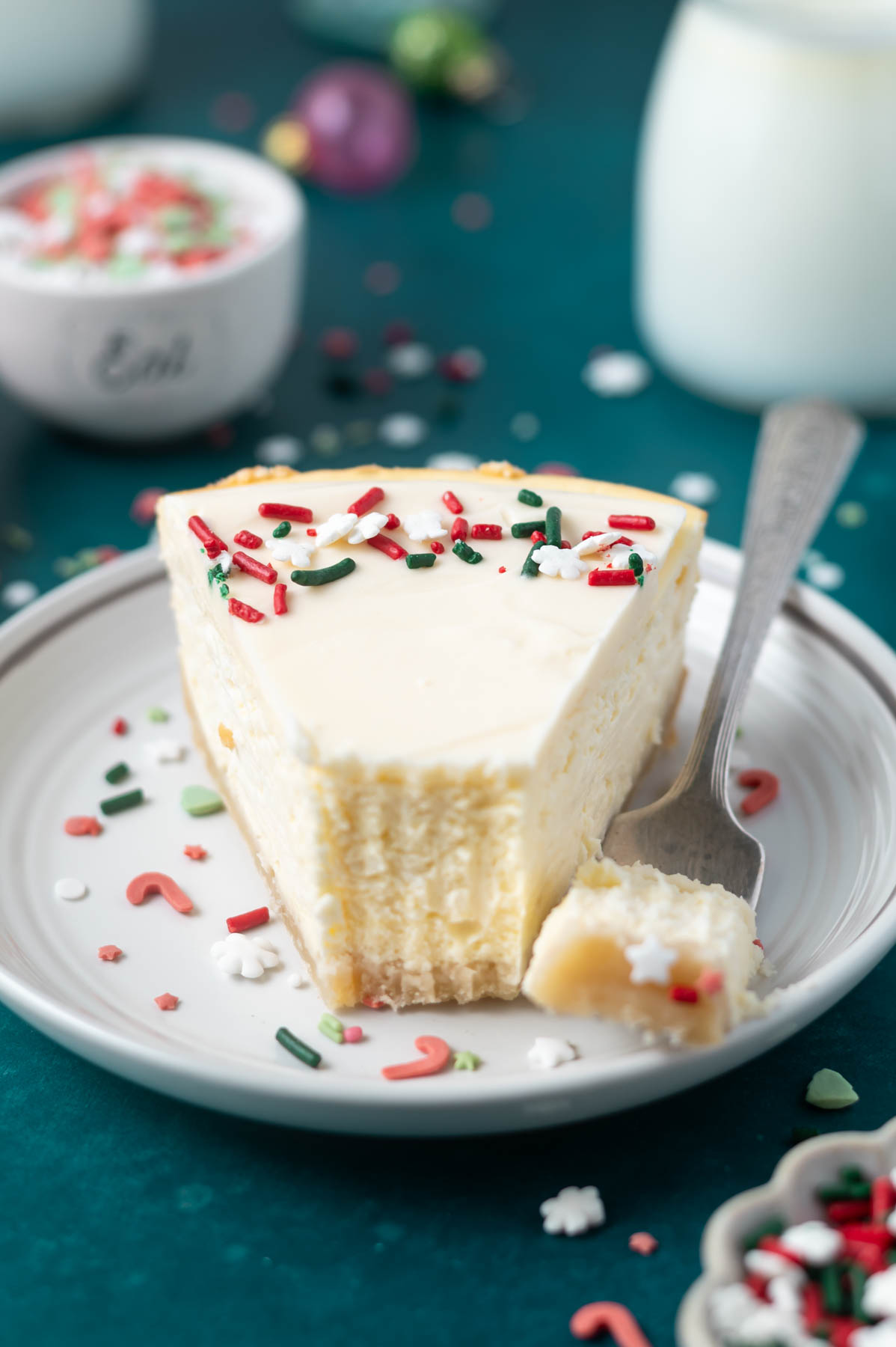 slice of sugar cookie cheesecake on a plate with a fork