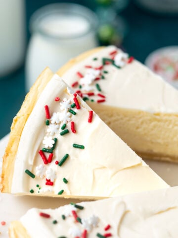 slices of sugar cookie cheesecake on a cake stand
