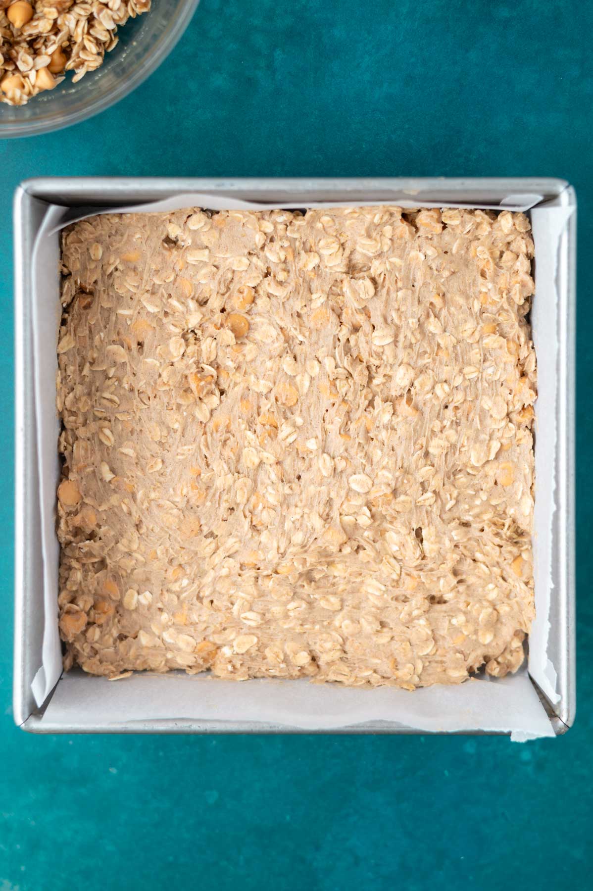 oatmeal bars batter in a parchment lined baking pan