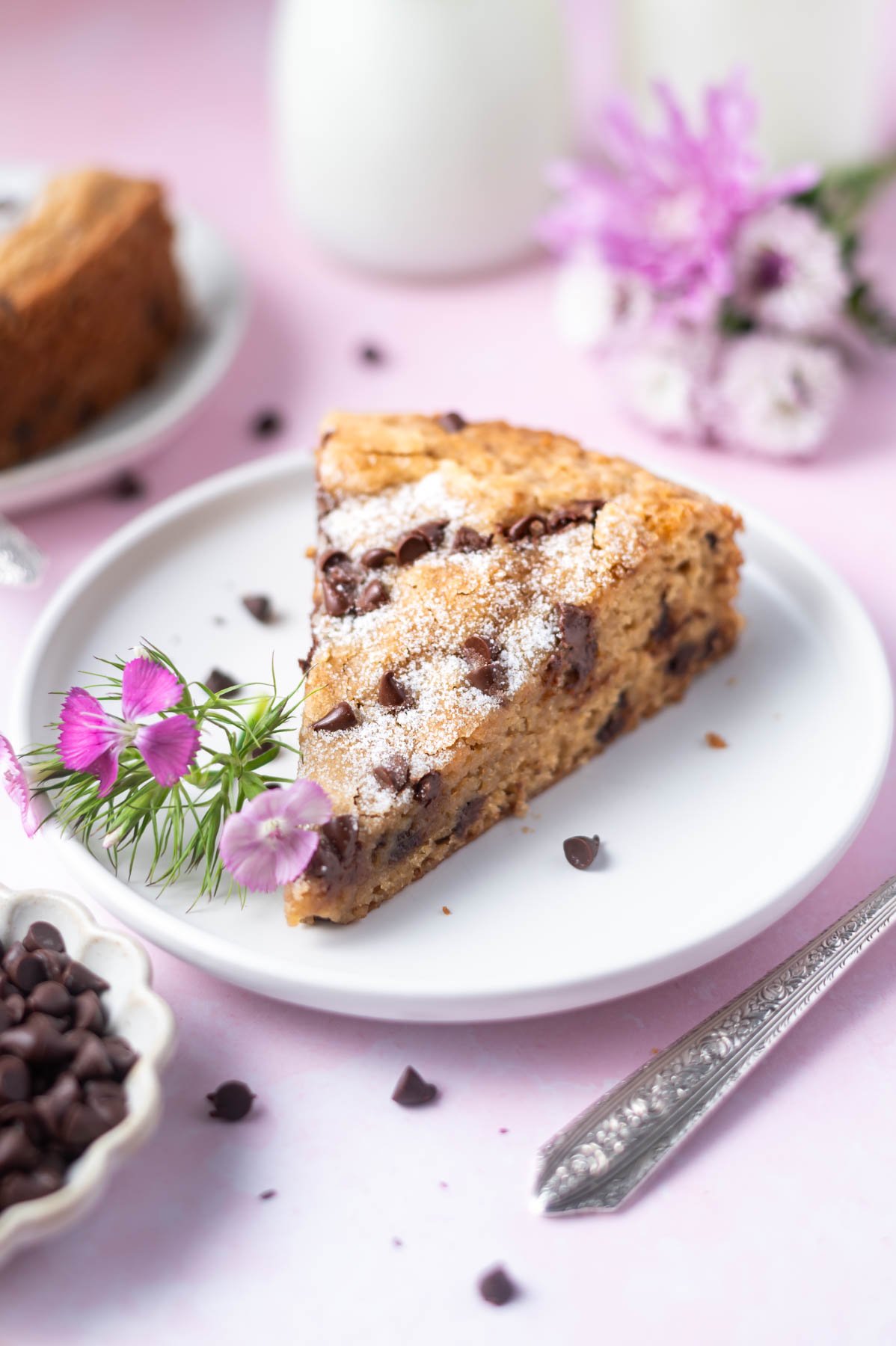 slice of cake on a plate with fresh flowers