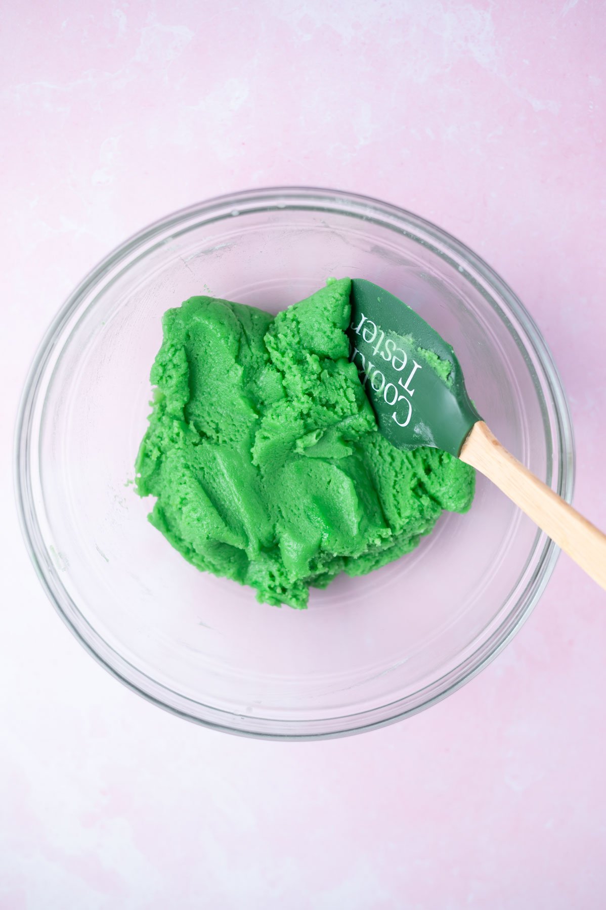 green sugar cookie dough in a bowl with a spatula