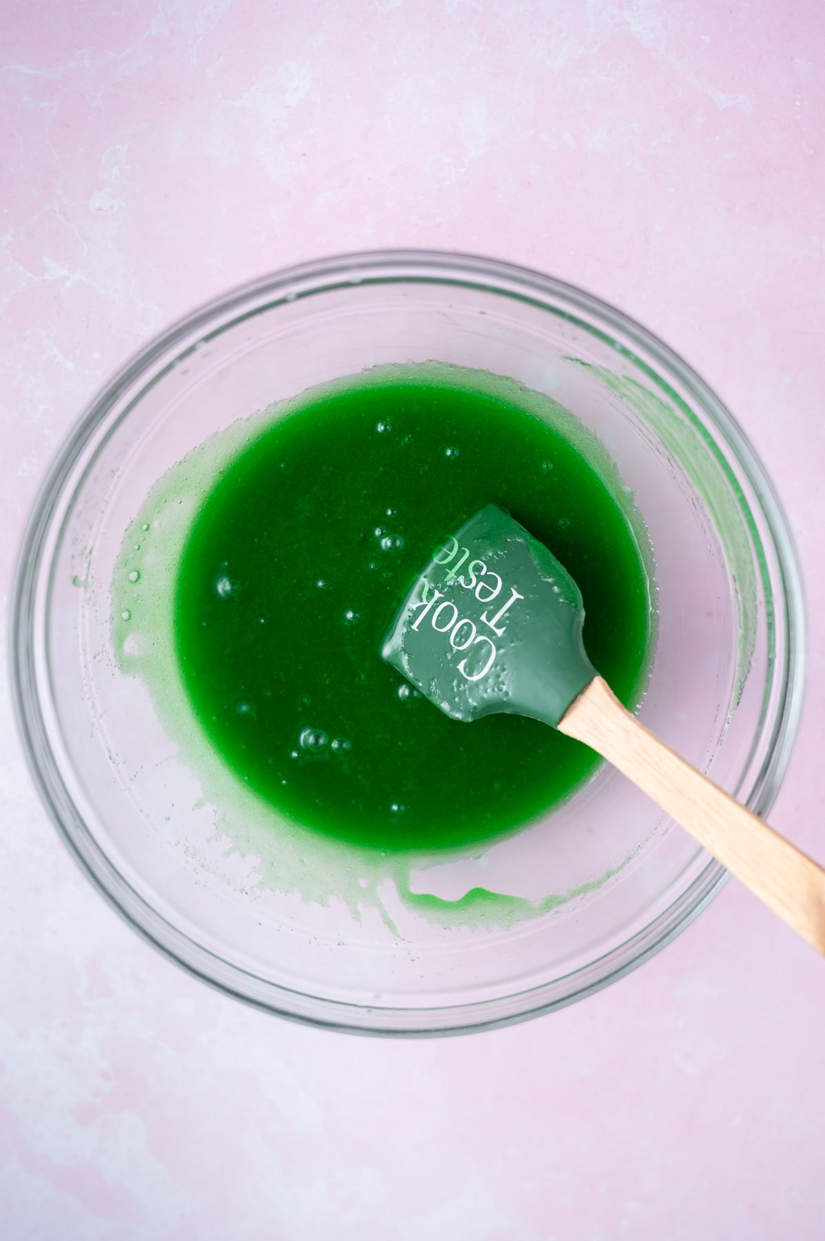 egg, vanilla and green food coloring added to cookie dough in a bowl