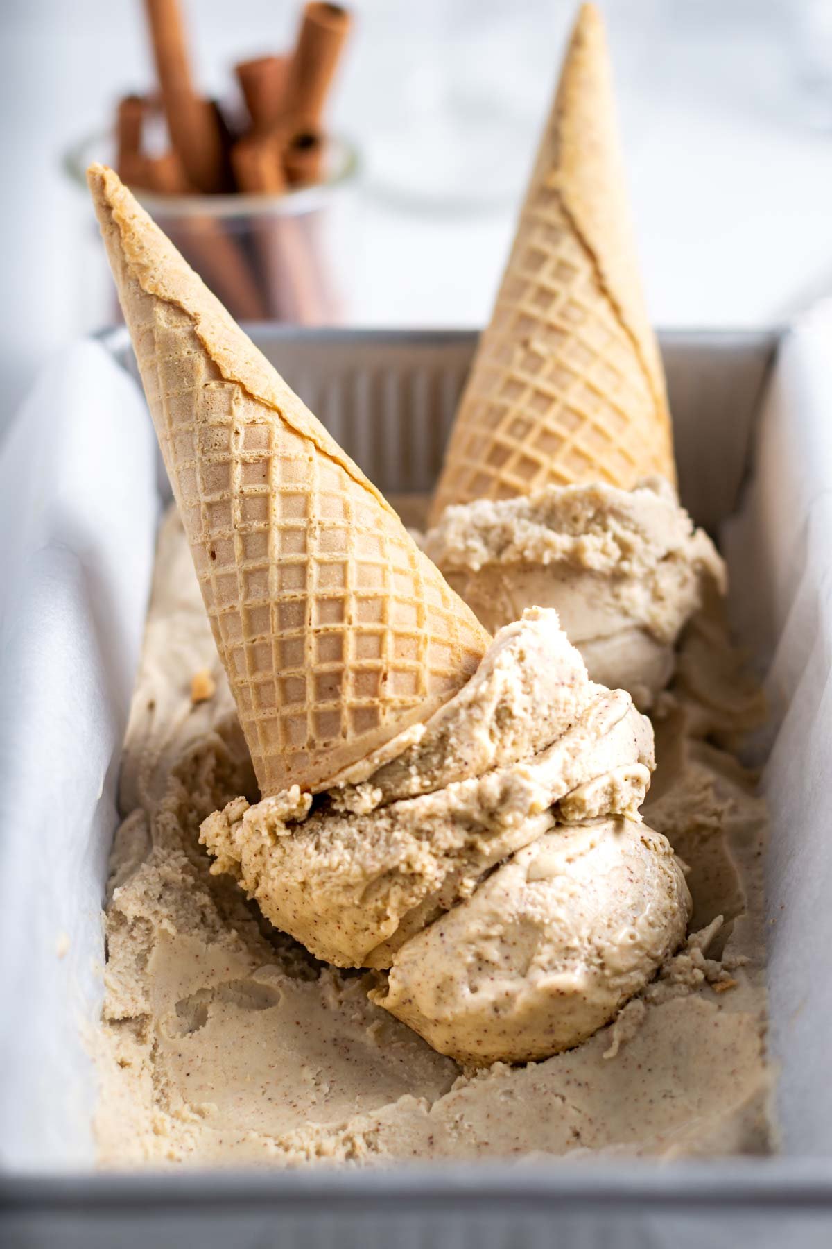 ice cream scooped into cones sitting in a container of ice cream