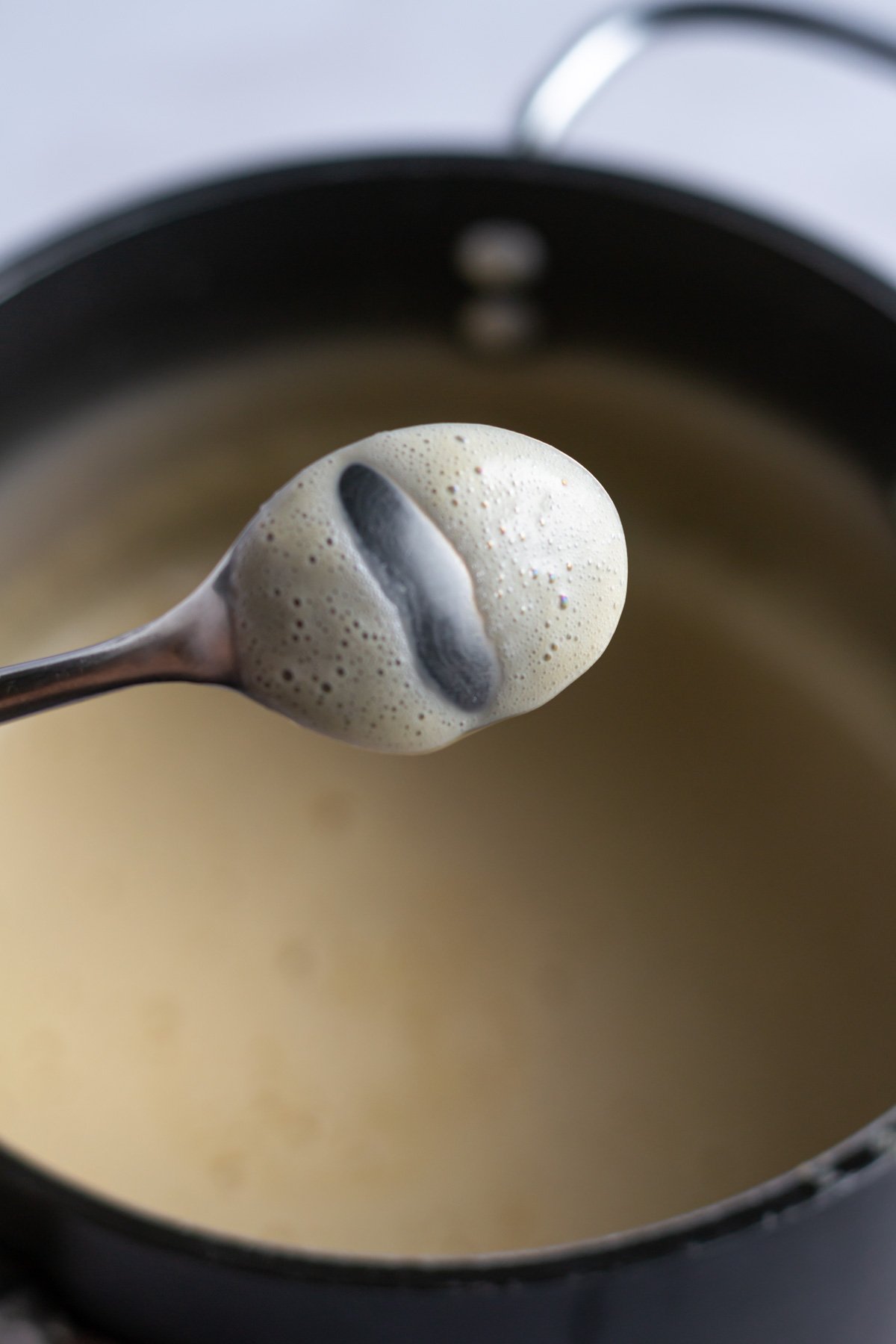 the back of a spoon with a finger run across the middle exposing the metal