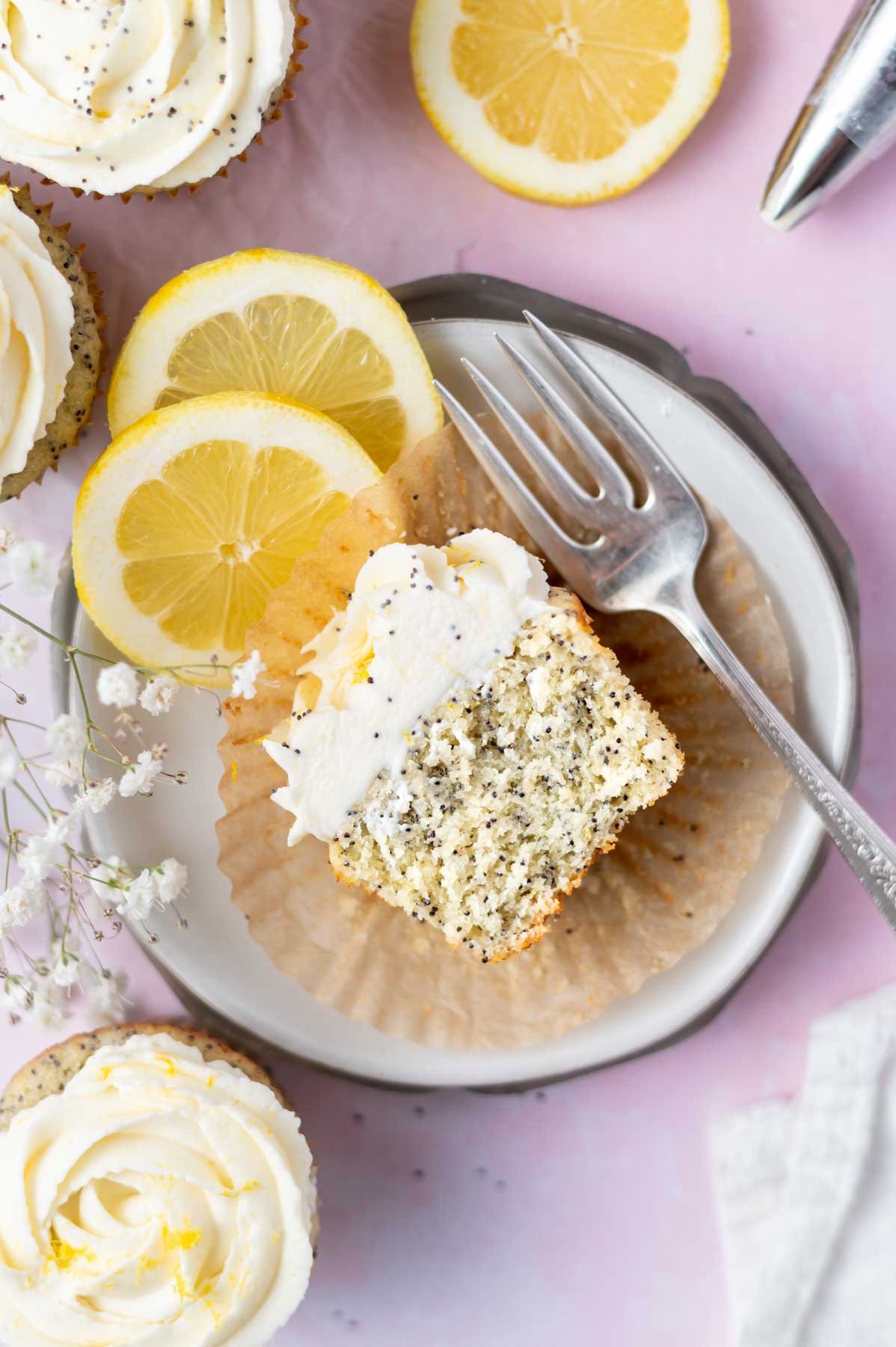 half cupcake on a plate with a fork and lemon slices