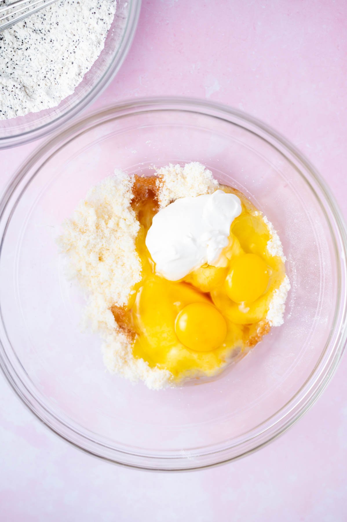 eggs, sour cream and vanilla added to lemon sugar in a glass bowl
