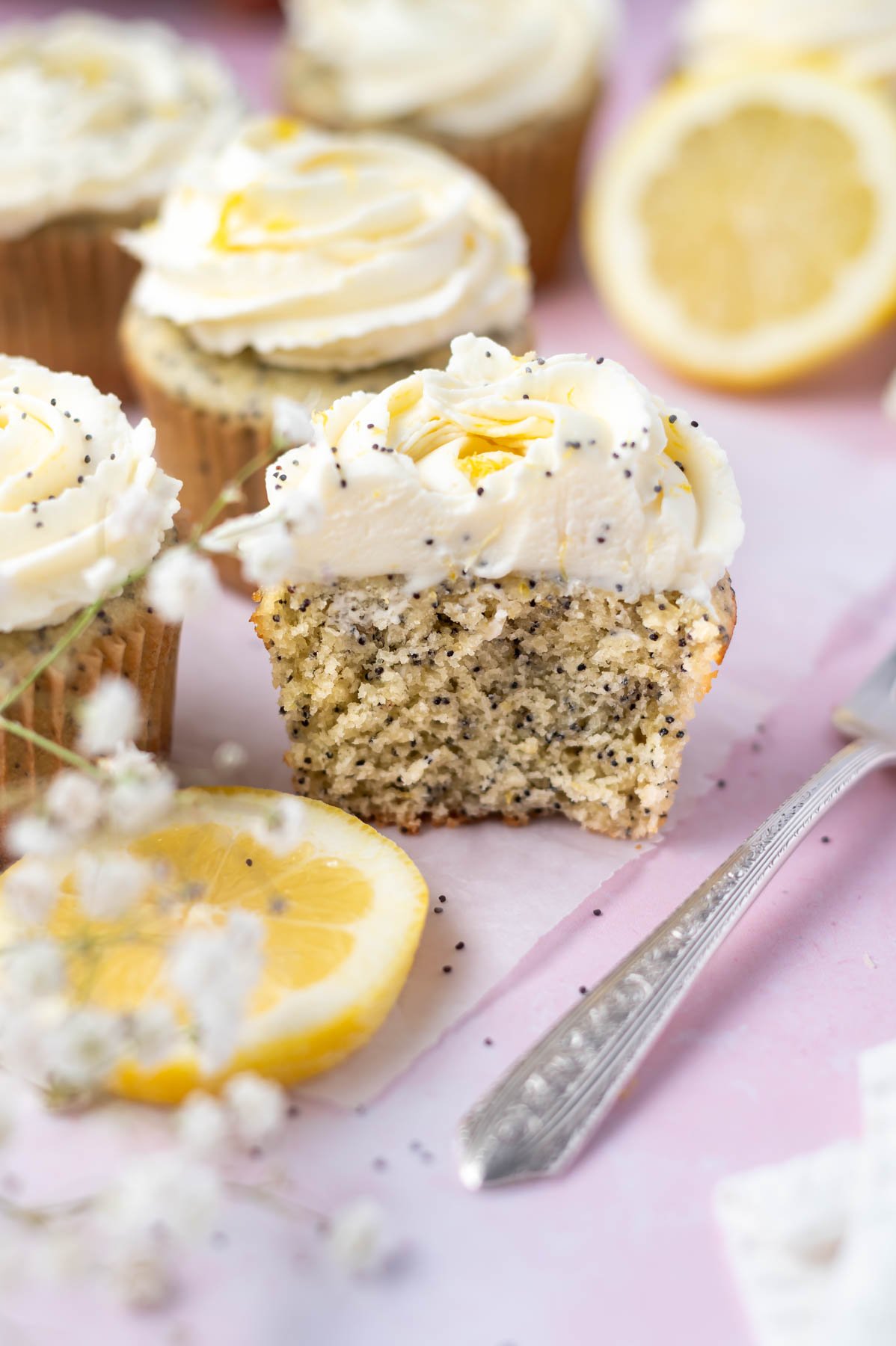 half a cupcake showing inside soft texture of lemon poppy seed cupcake with a fork