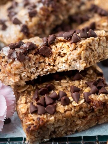 breakfast bar with a bite missing leaning against another bar with milk in the background