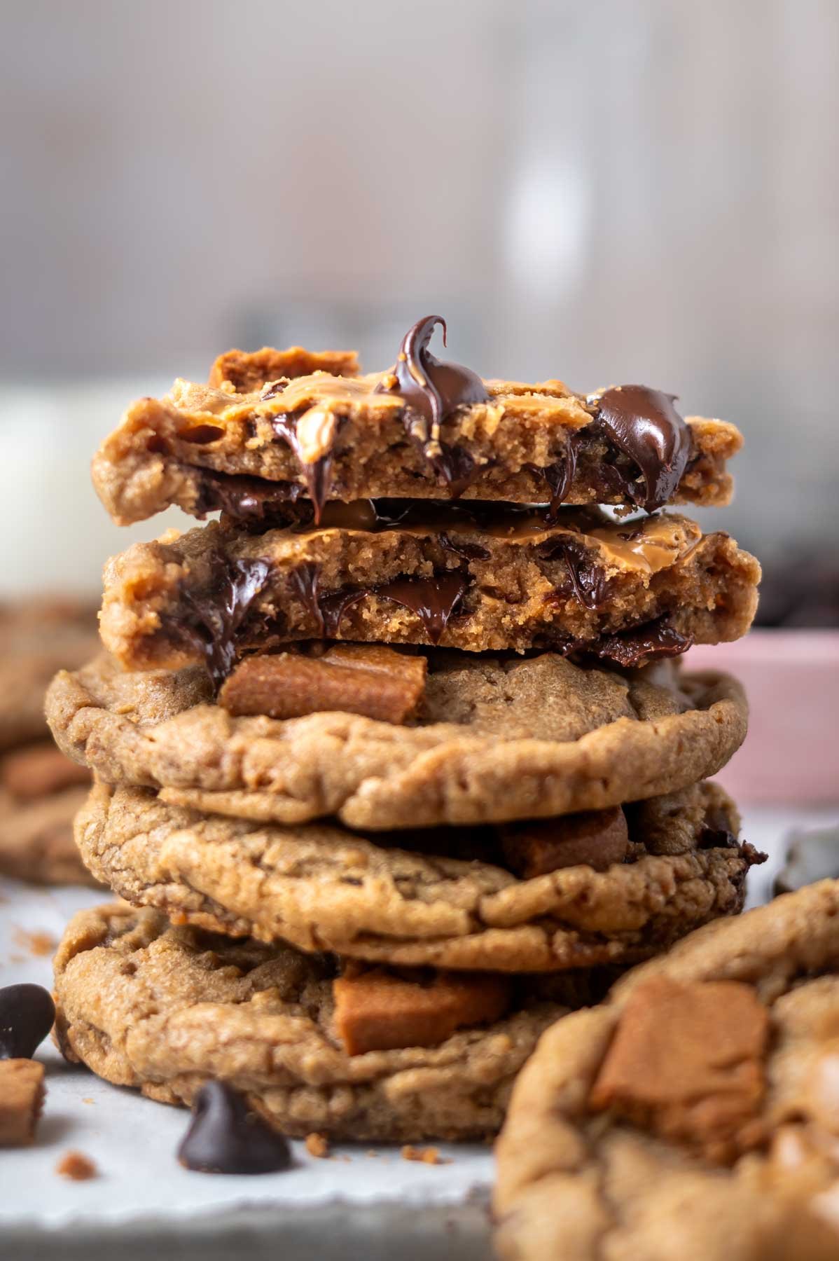 stack of cookies with the top one broken showing the soft texture and the whole cookies showing the crispy edges