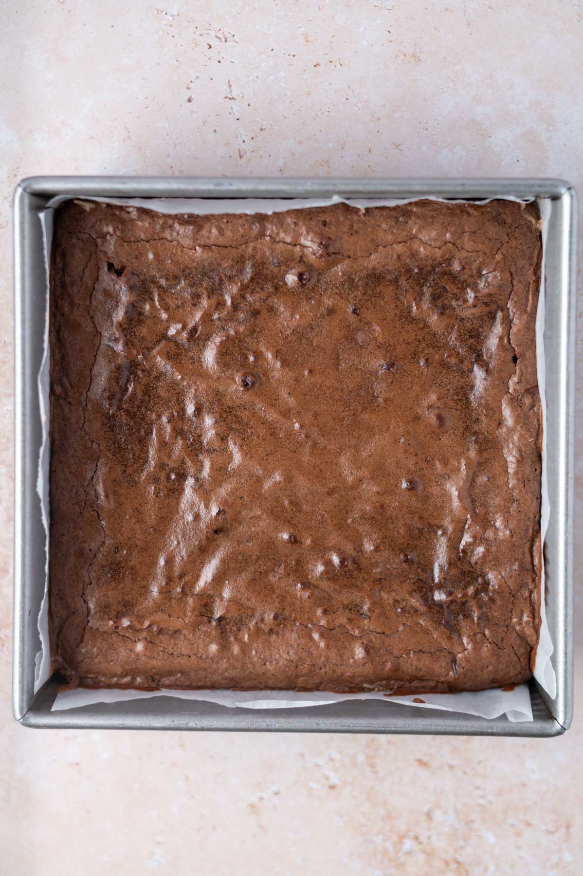 baked coconut brownies in a parchment lined baking pan