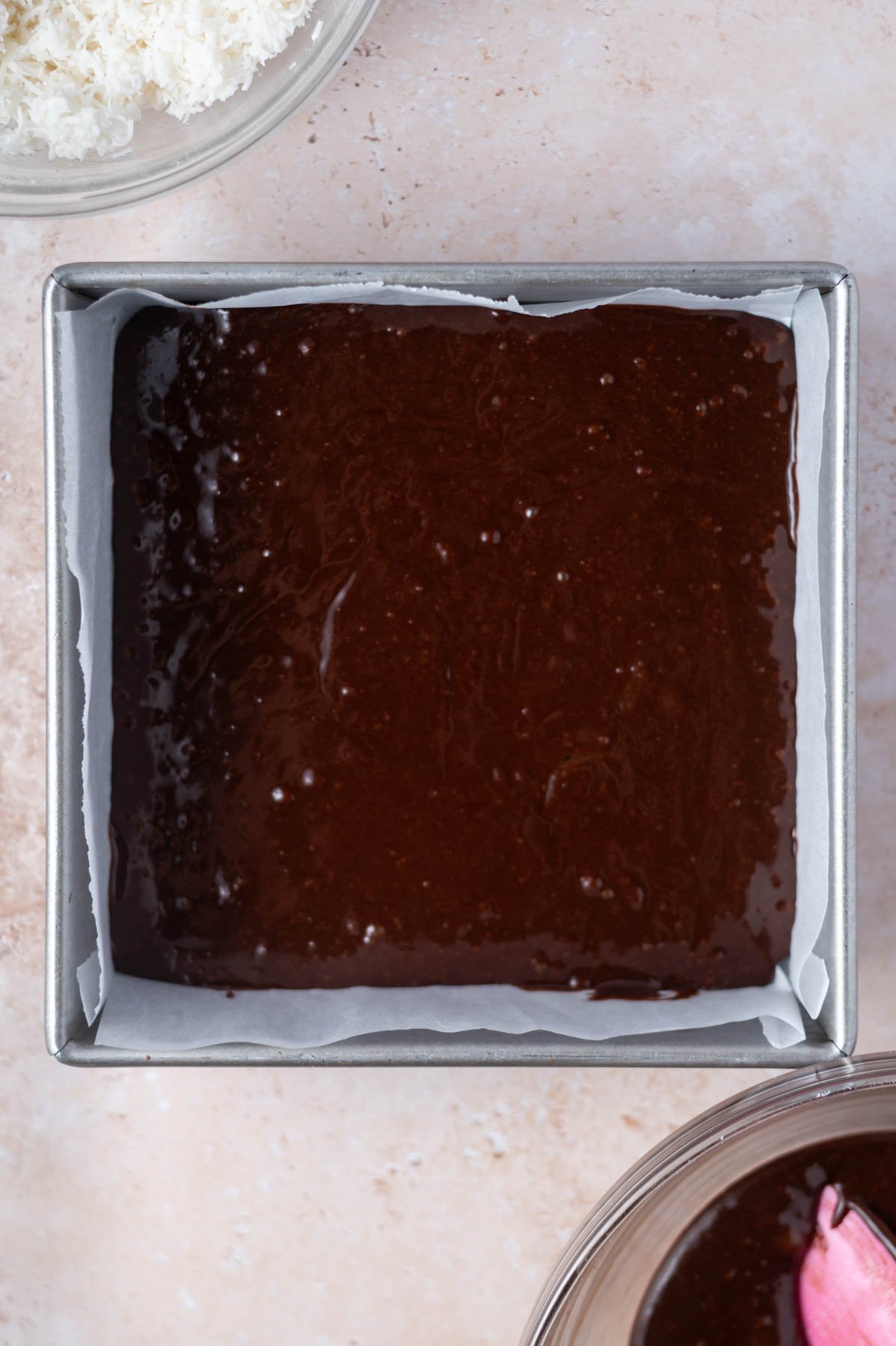 brownie batter in a parchment lined baking tin