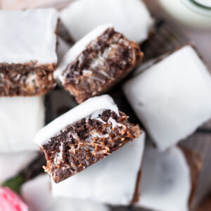 pile coconut brownies with one showing coconut stuffed middle