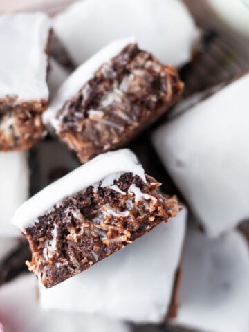 pile coconut brownies with one showing coconut stuffed middle