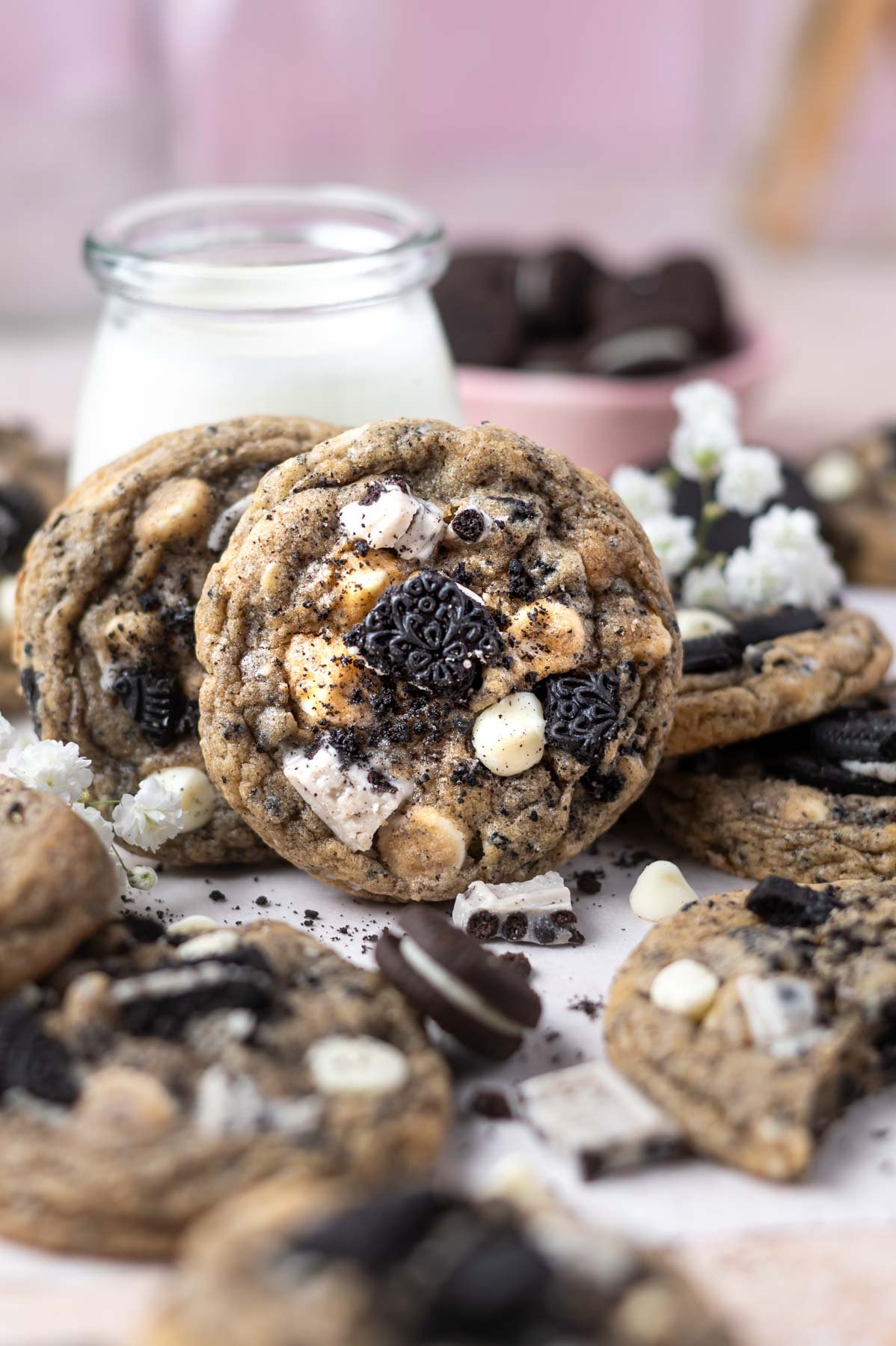 pile of cookies with two leaning against a glass of milk
