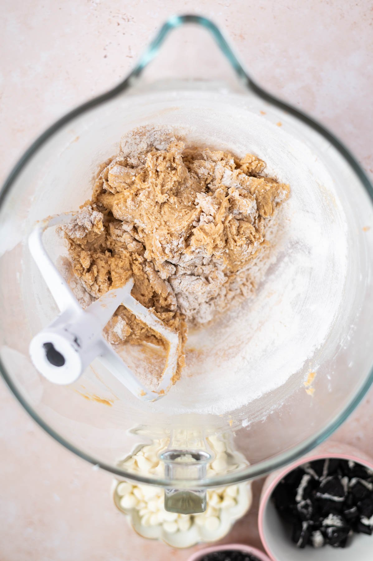cookie dough with large streaks of flour remaining in a mixing bowl