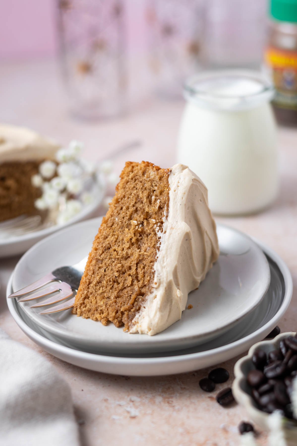 slice of cake on a plate with a fork and a glass of milk in the background