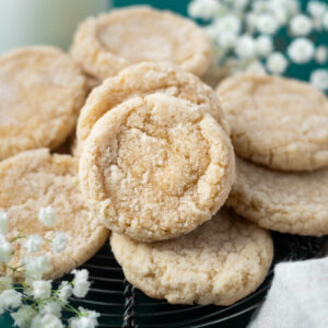 vanilla bean sugar cookies on a cooling rack with fresh flowers in the background