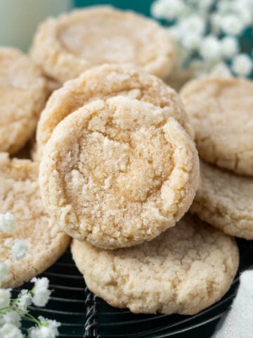 vanilla bean sugar cookies on a cooling rack with fresh flowers in the background