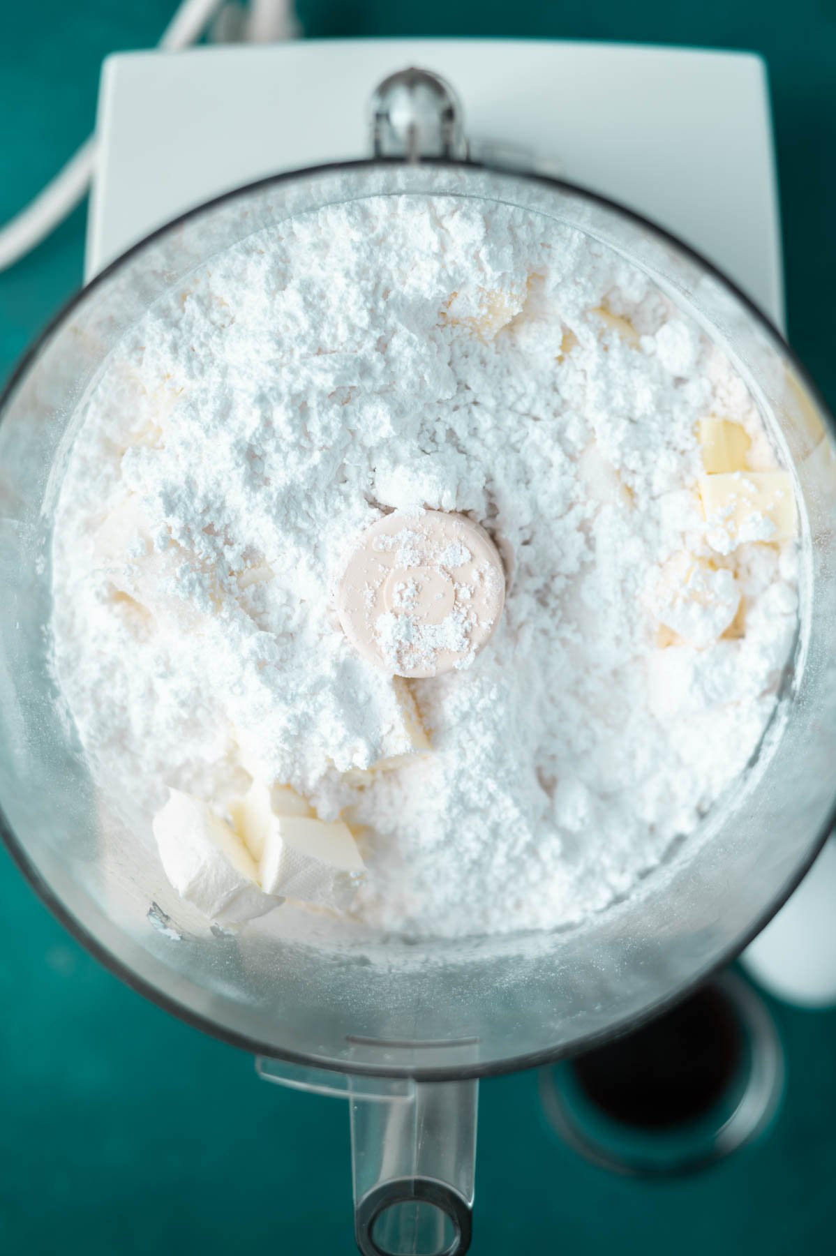 butter, cream cheese, granulated and confectioners' sugar in a food processor bowl