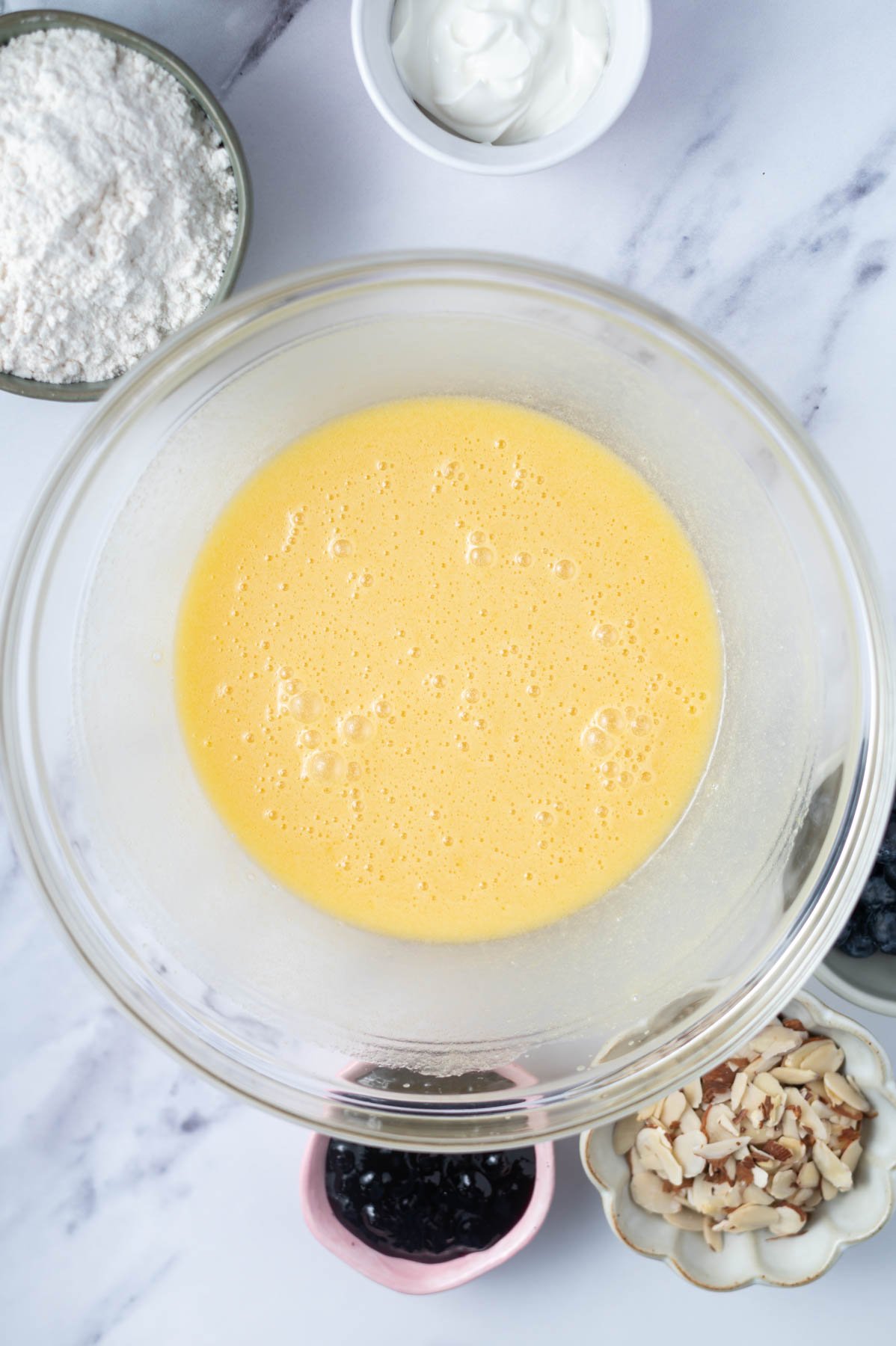eggs whisked into cake batter in a glass bowl