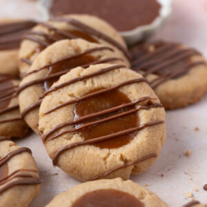cookies leaning up against one another with a bowl of caramel in the background