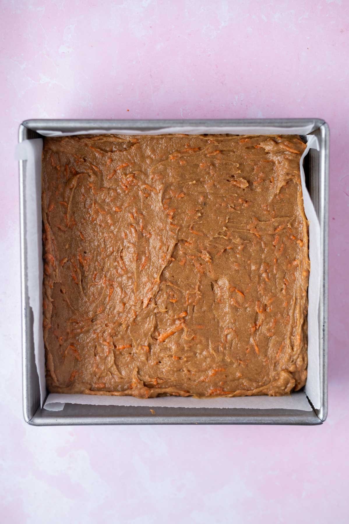 carrot cake blondie batter in parchment lined baking pan