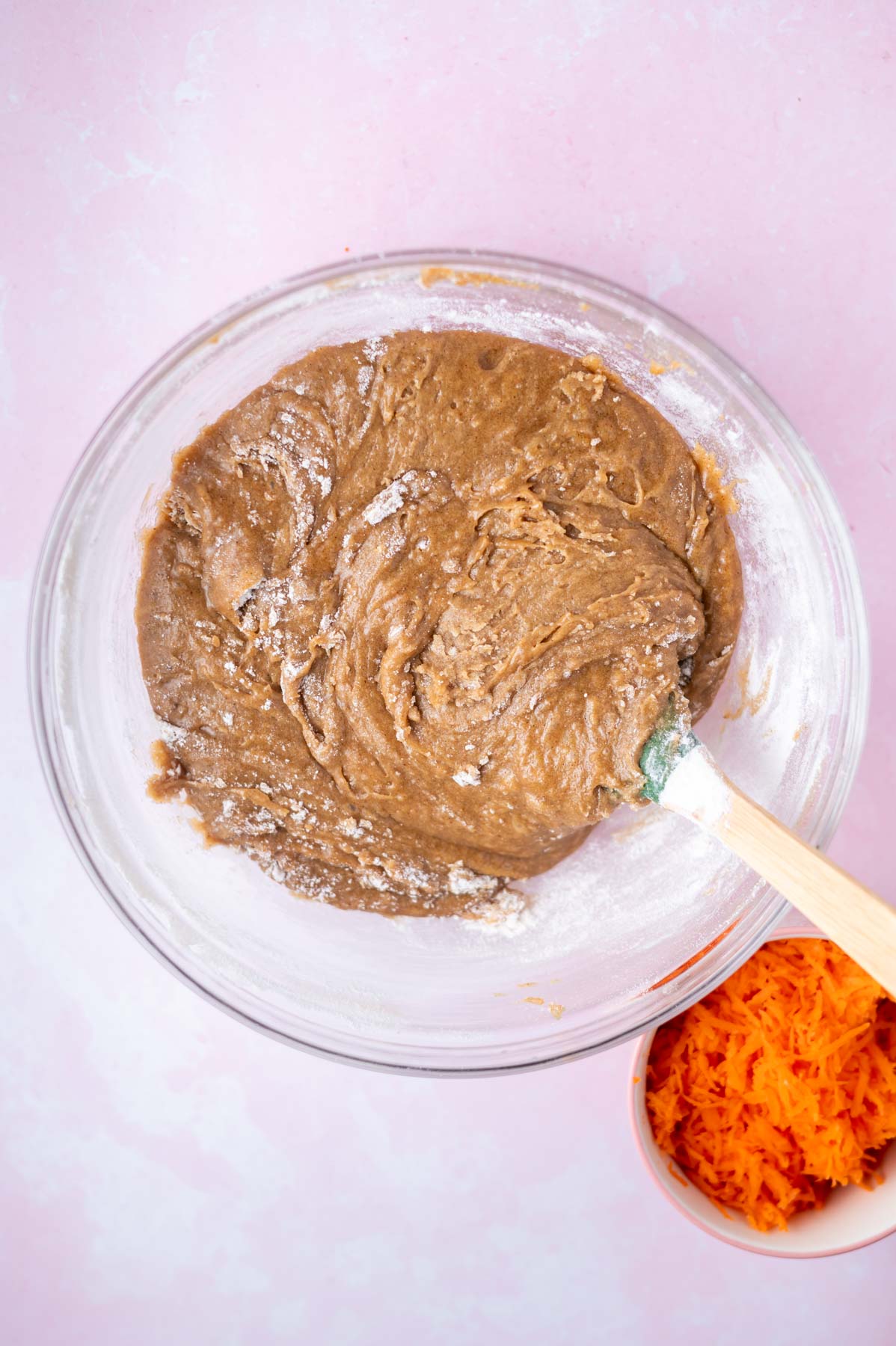 blondie batter with a few streaks of flour showing in a glass bowl with a spatula