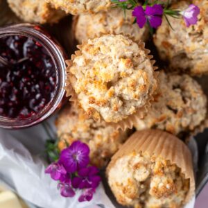 overhead look at Irish soda bread muffins with a jar of jam and fresh purple flowers