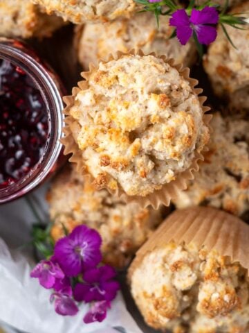 overhead look at Irish soda bread muffins with a jar of jam and fresh purple flowers