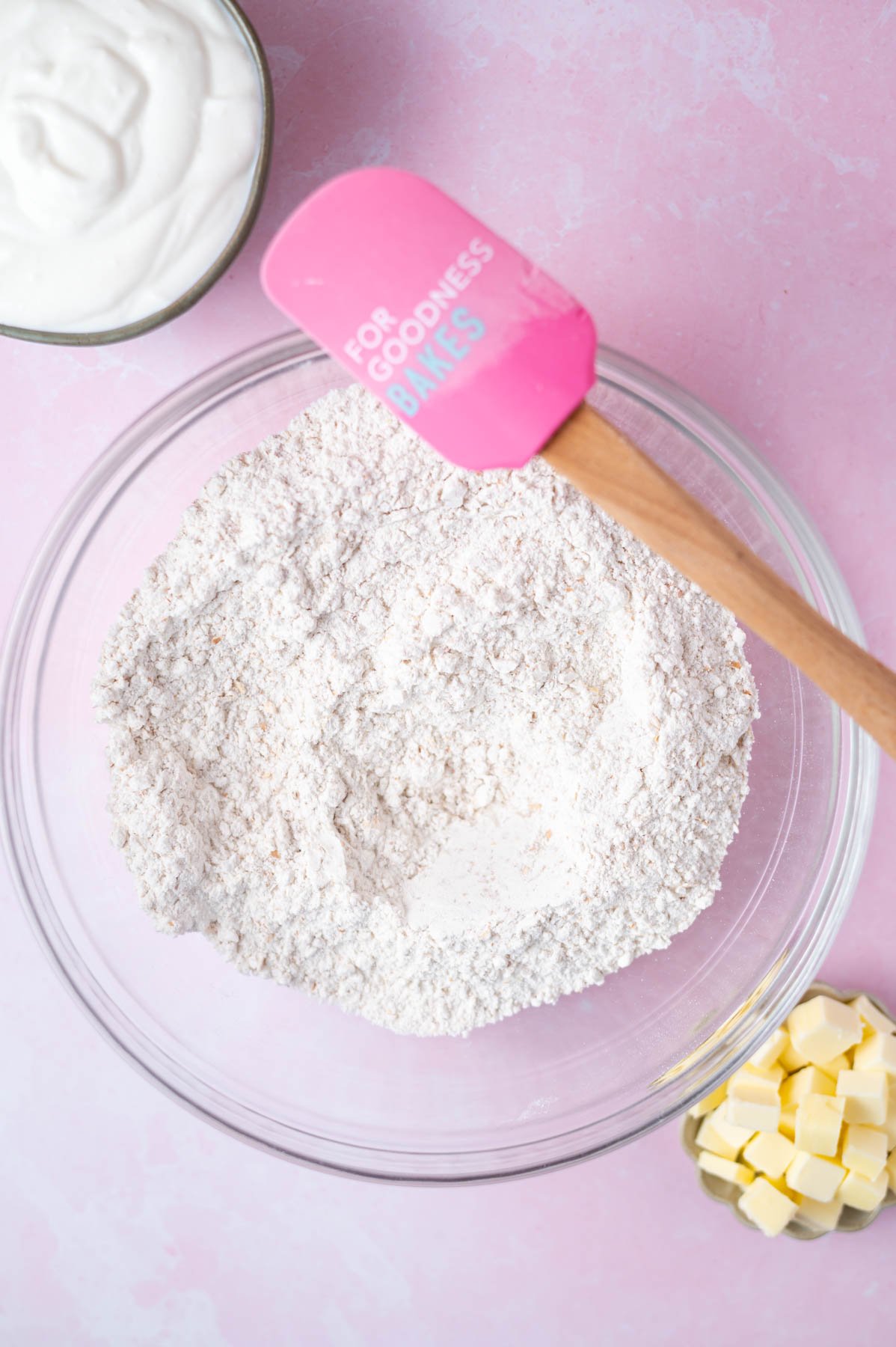 dry ingredients mixed together in a bowl with a pink spatula