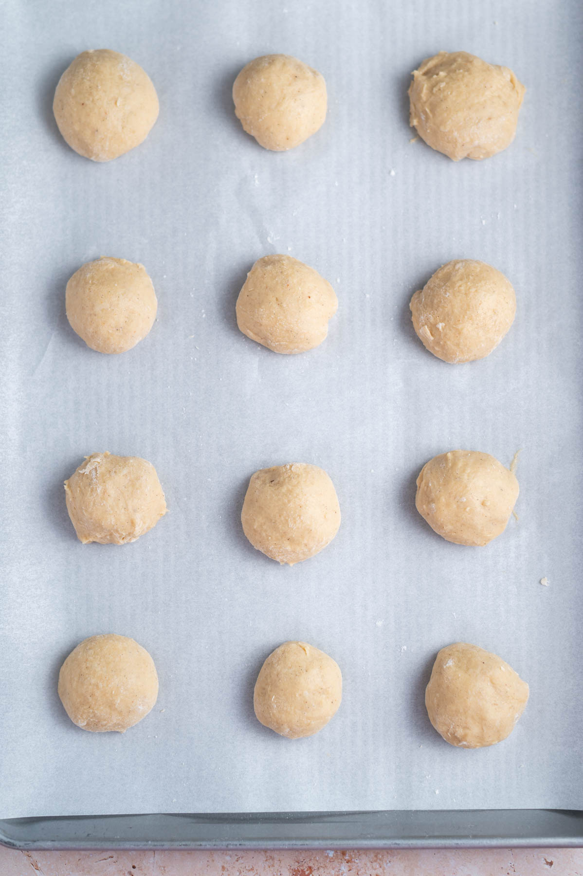 12 donuts resting on parchment lined baking pan