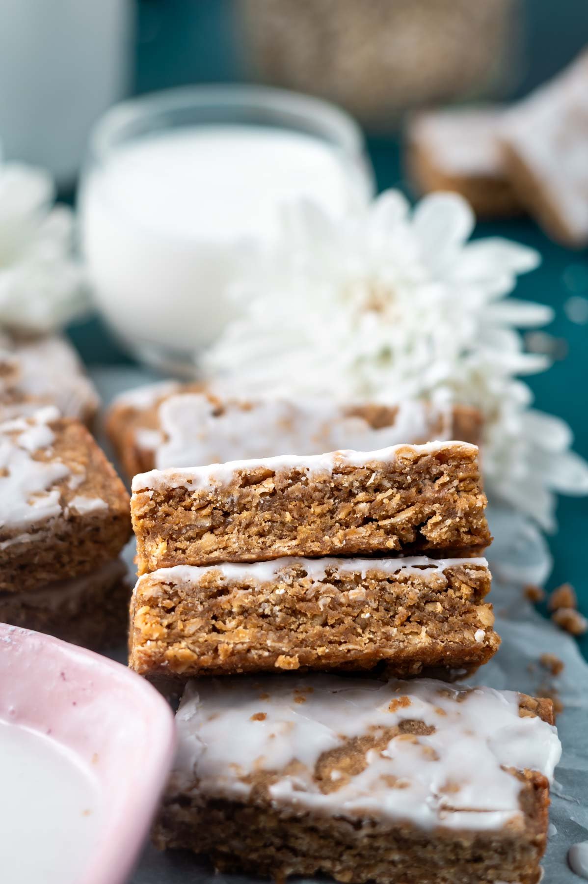 two cookie bars leaning up showing soft and chewy texture with a glass of milk in the background