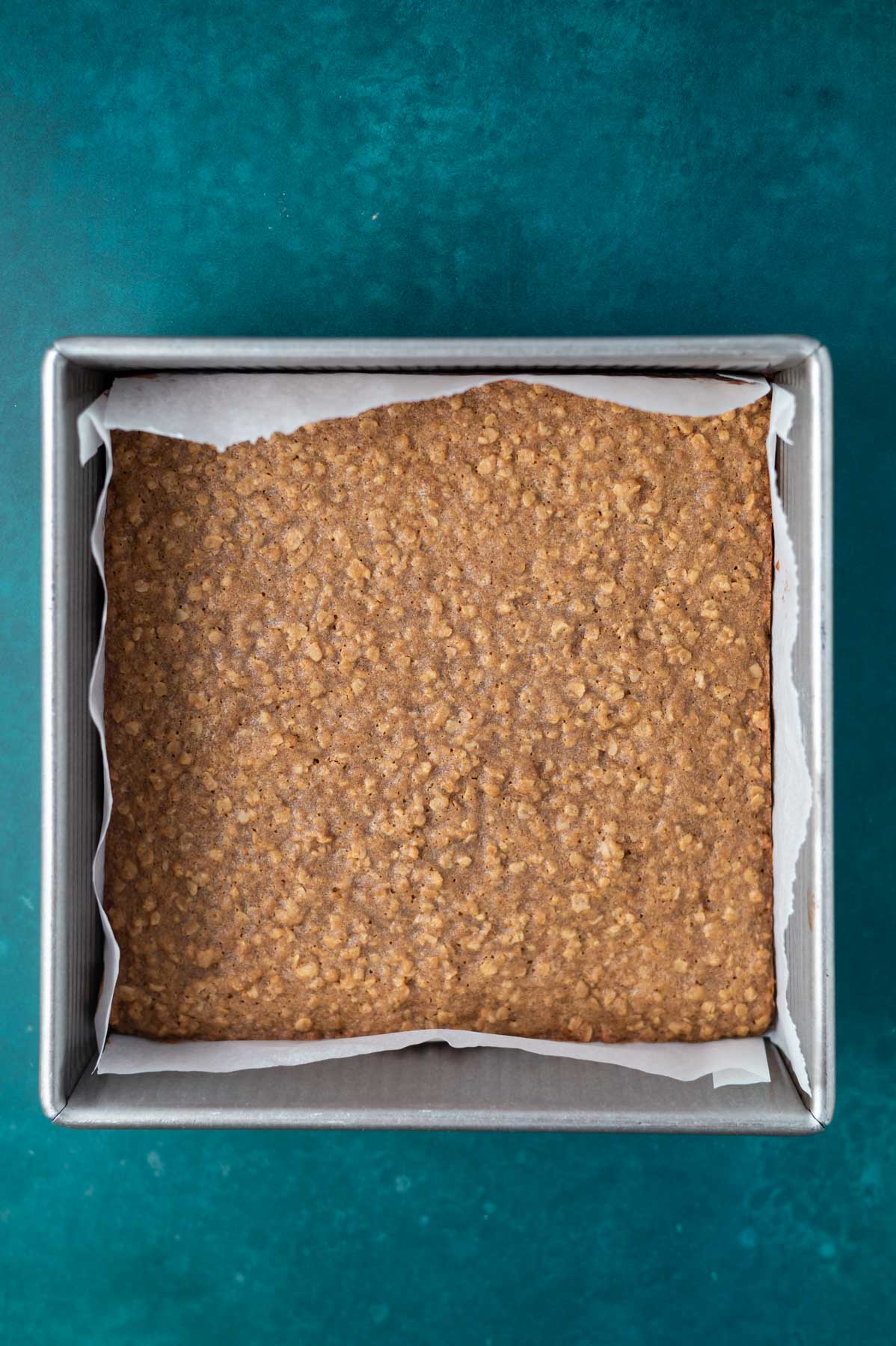 baked cookie bars in a parchment lined pan