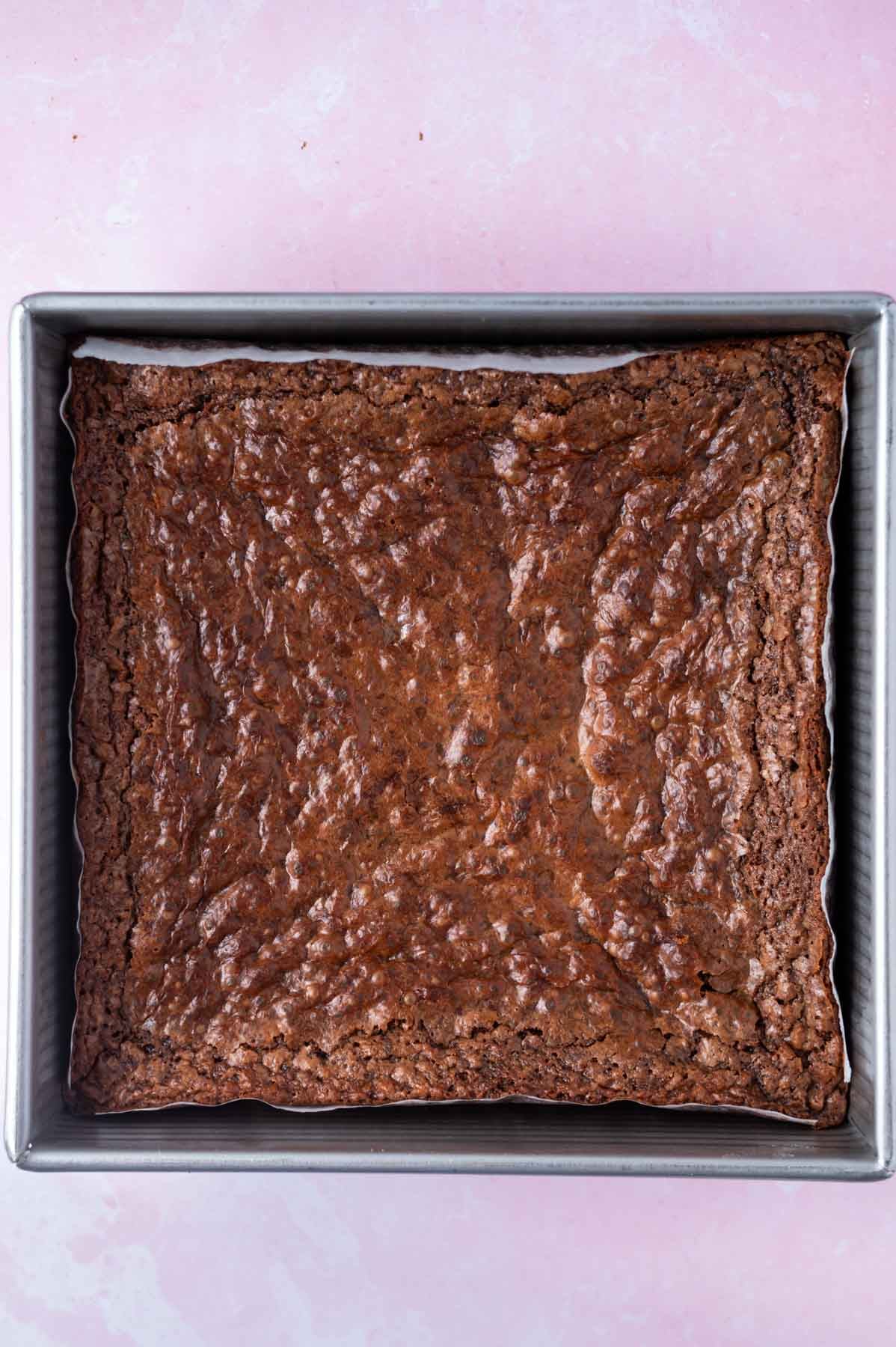 baked brownies in a parchment lined baking tin