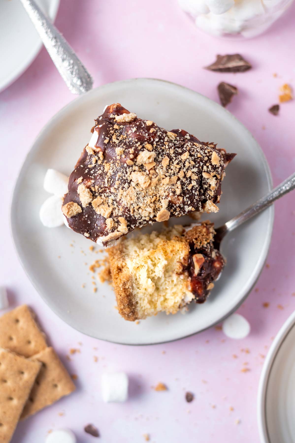 slice of s'mores cake on a plate with a bite on a fork