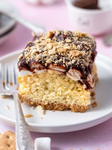 slice of s'mores cake on a plate with a fork