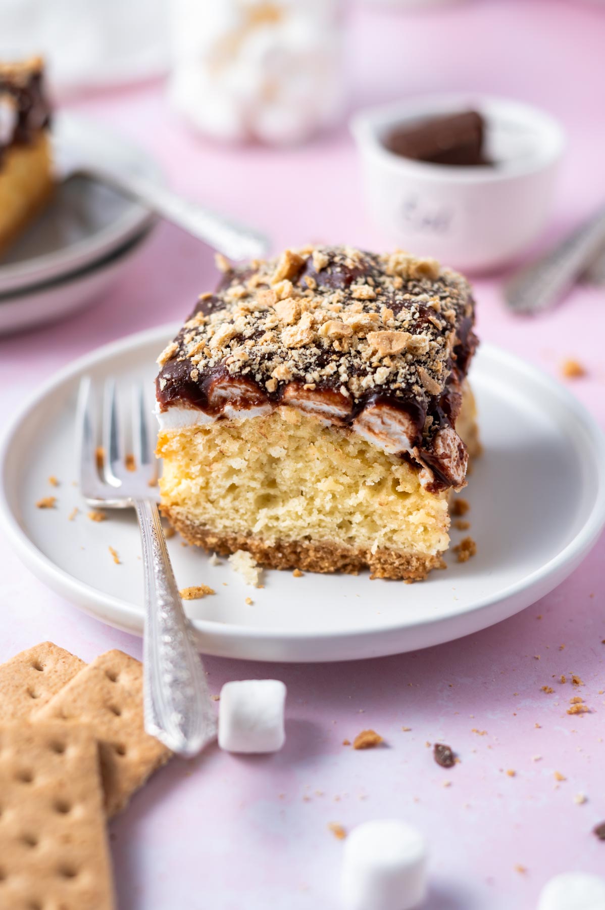 slice of s'mores cake on a plate with a fork