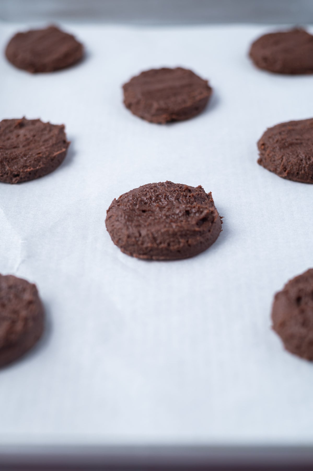 cookie dough pressed down on a parchment lined baking sheet
