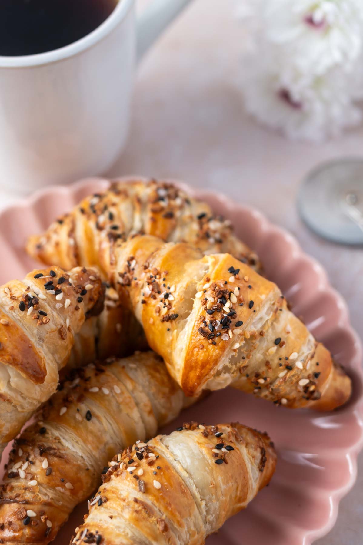 croissants on a pink plate with a cup of coffee